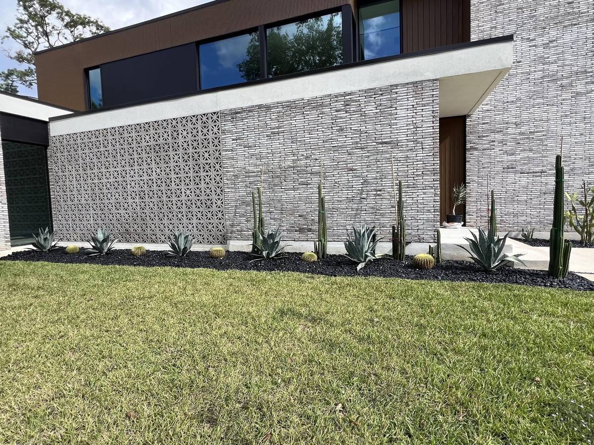 Modern landscape with decorative stone and drought-tolerant plants in Houston